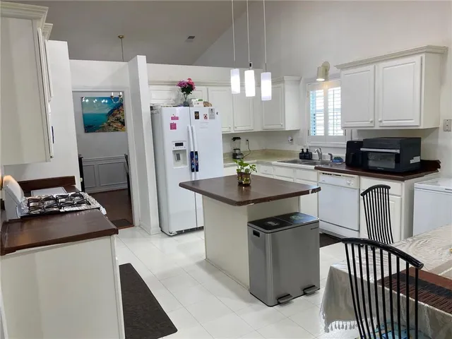 a kitchen with stainless steel appliances granite countertop a stove top oven a sink a dining table and chairs
