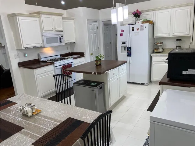 a view of kitchen island with stainless steel appliances granite countertop sink table and chairs