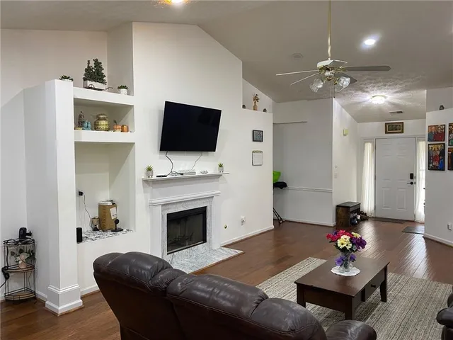 a living room with furniture a fireplace and a flat screen tv