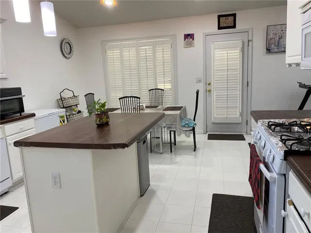 a kitchen with stainless steel appliances a kitchen island a stove a table and chairs