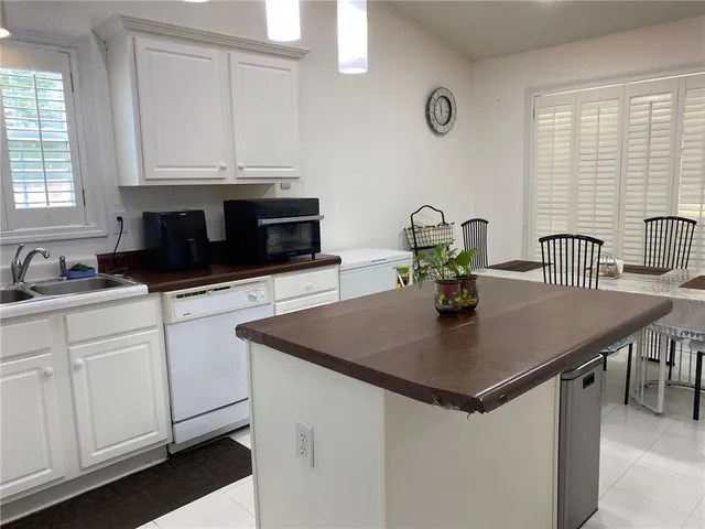 a kitchen with stainless steel appliances granite countertop a refrigerator sink stove and white cabinets