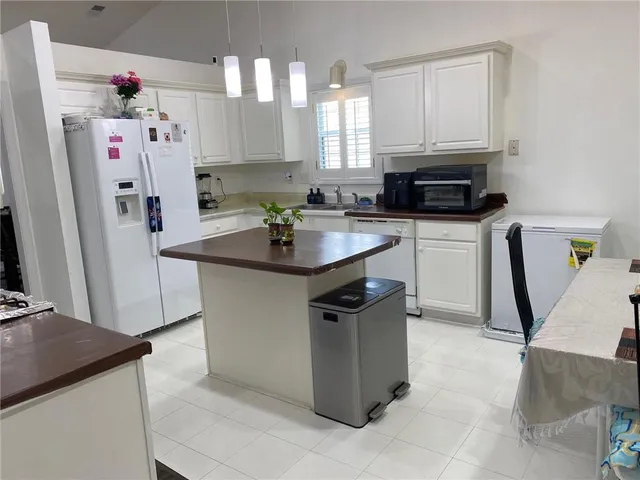 a kitchen with kitchen island a sink stove and refrigerator