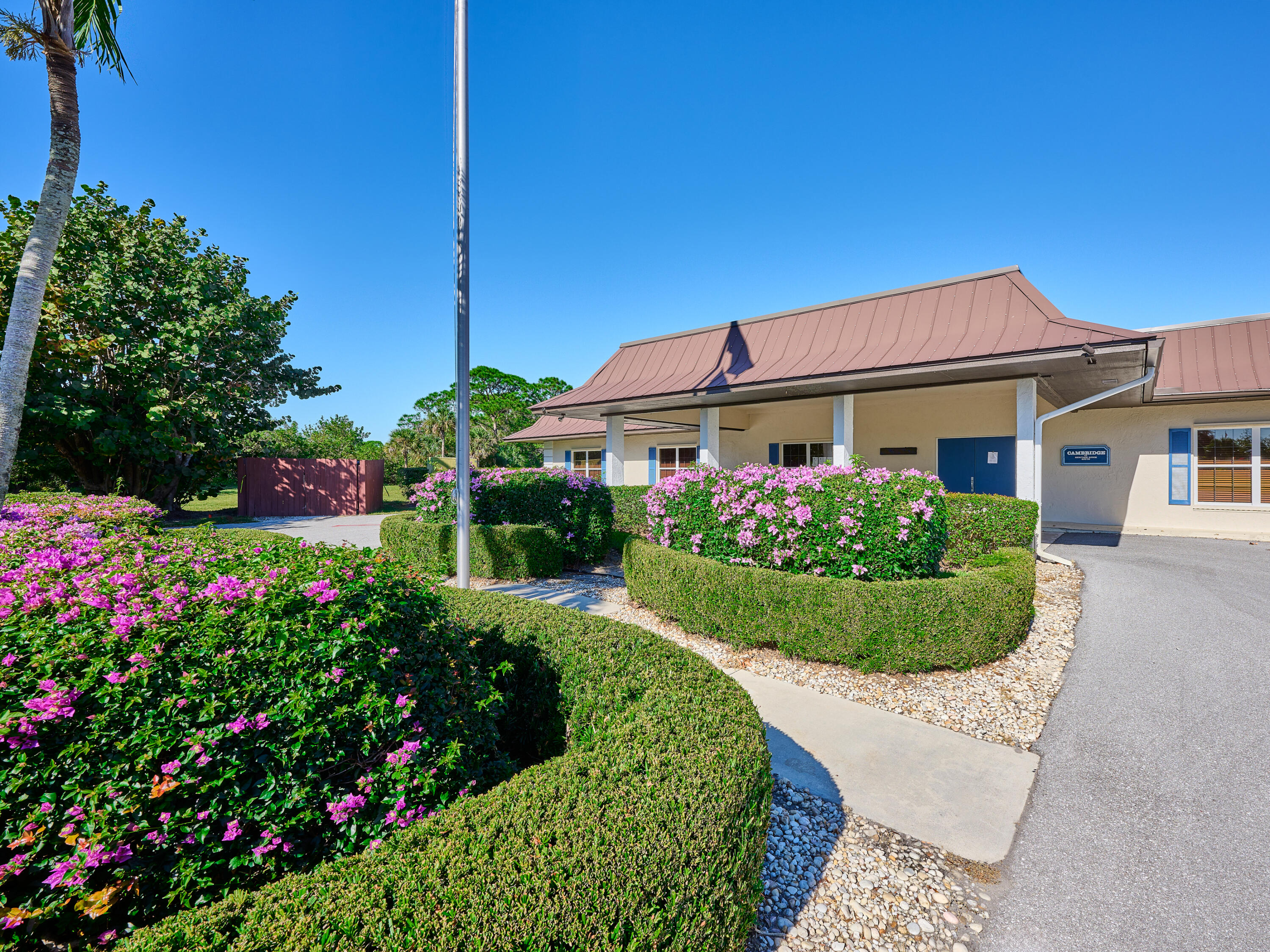 6977 Southeast Delegate Street Hobe Sound, FL 33455 - Photo 50 of 60 a front view of a house with a yard