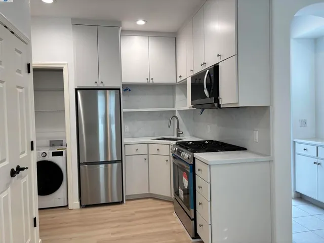 a kitchen with stainless steel appliances granite countertop a stove a refrigerator and a microwave