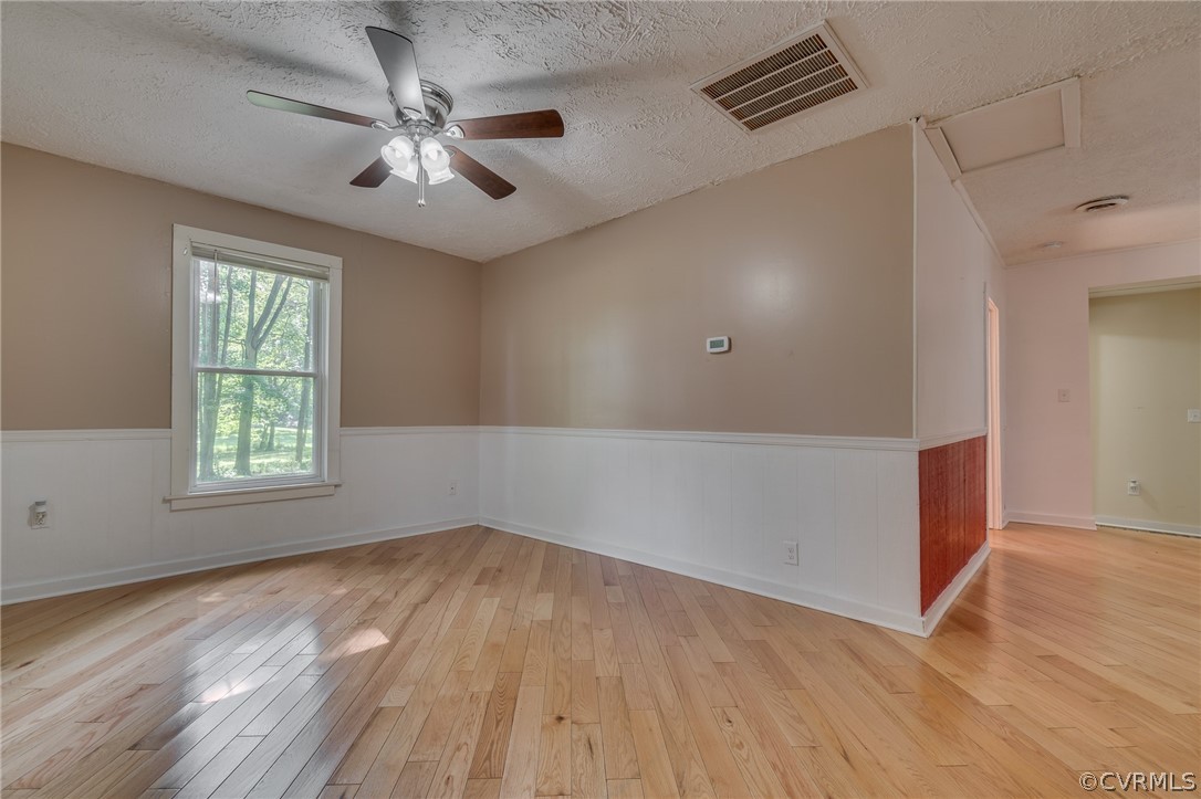 1429 Fredericks Hall Road Bumpass, VA 23024 - Photo 6 of 30 an empty room with wooden floor chandelier fan and windows
