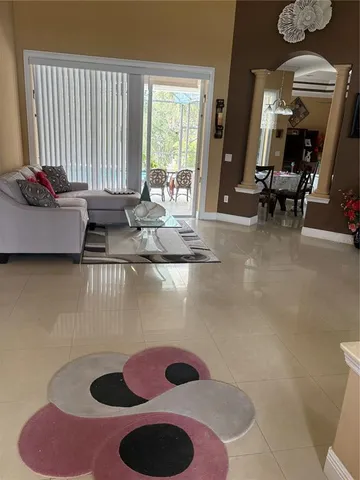 a living room with furniture and a floor to ceiling window