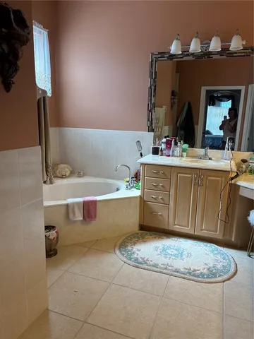 a bathroom with a tub sink and mirror