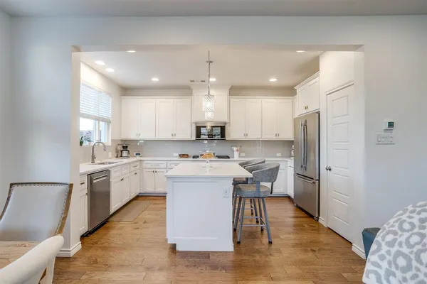 a kitchen with white cabinets and sink