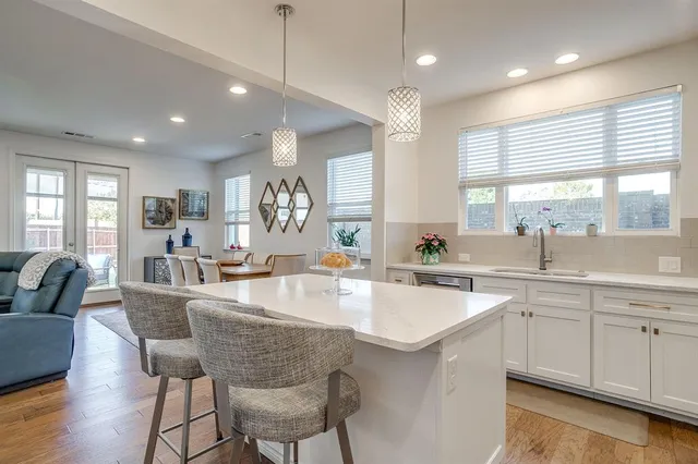 a large kitchen with kitchen island white cabinets and couches
