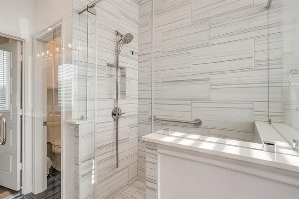a bathroom with a granite countertop shower and a sink