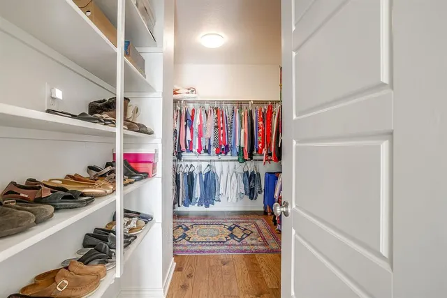 a view of walk in closet with clothes and shoes