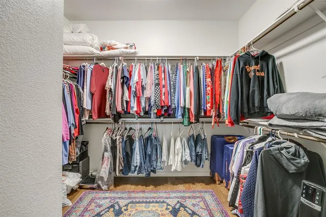 a view of walk in closet with clothes