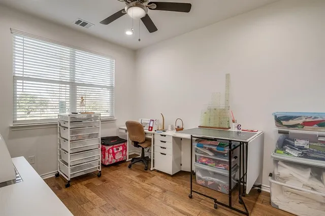 a view of a workspace with furniture and a window