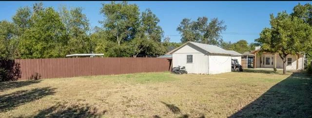a view of white house with a yard and large tree