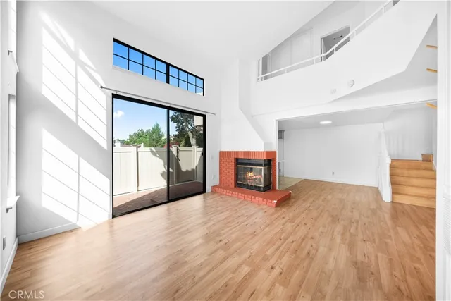a view of empty room with wooden floor and fireplace