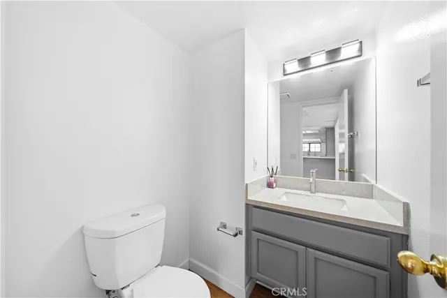 a bathroom with a granite countertop sink a toilet and a mirror