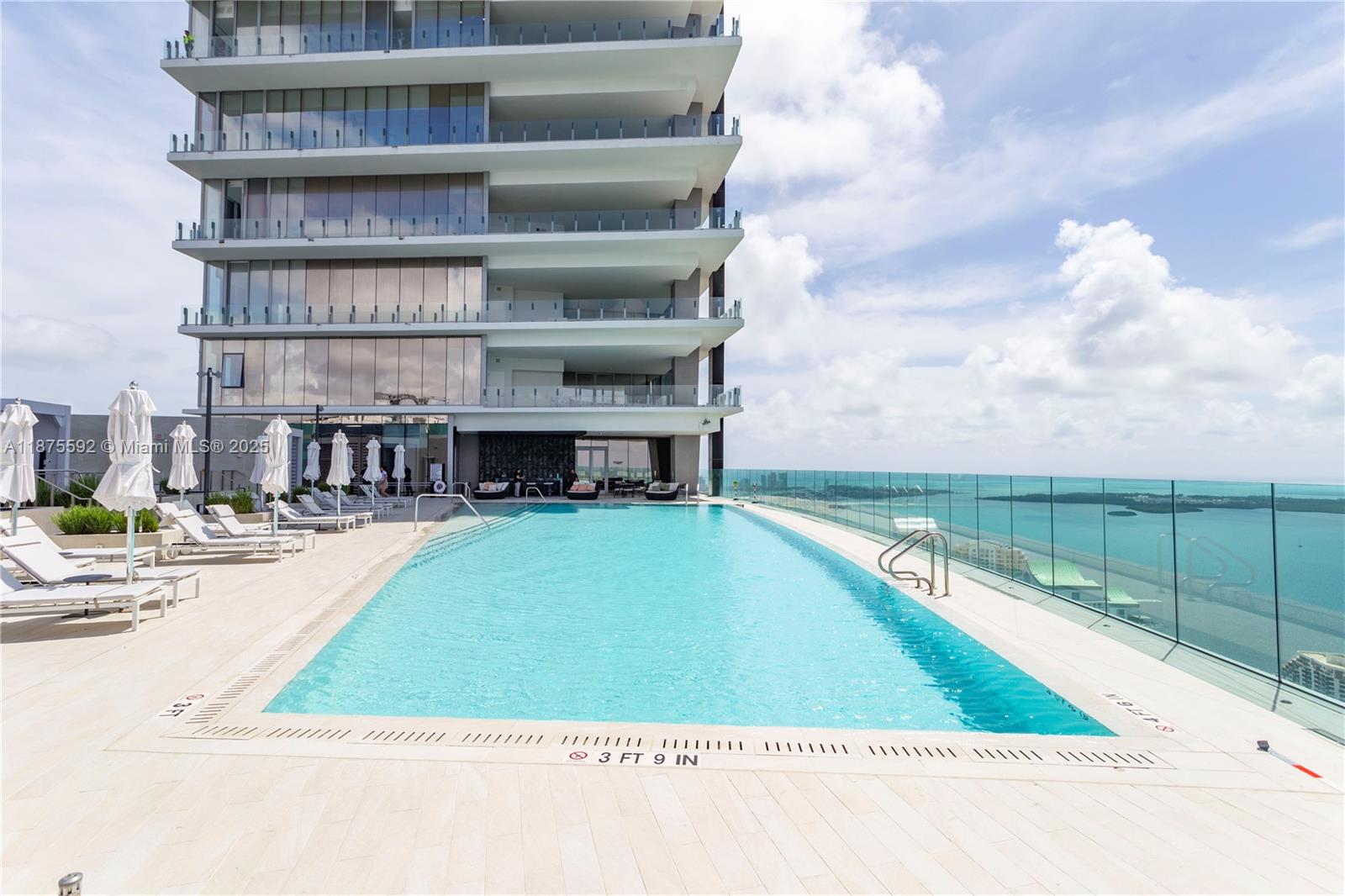 300 Biscayne Blvd Way, Unit 5002 Miami, FL 33131 - Photo 53 of 69 a view of a swimming pool with a chair and tables in the background