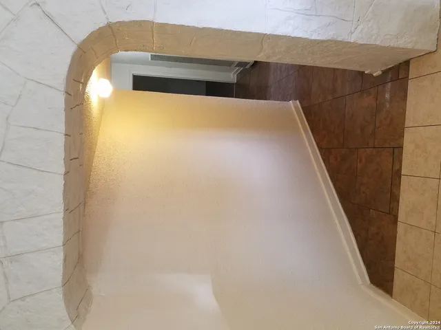 a view of staircase with white walls and a window