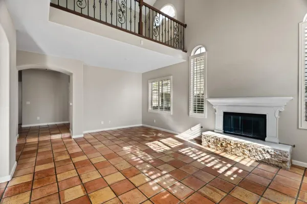 a view of an empty room with window and fireplace