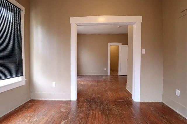 a view of a room with wooden floor and a window