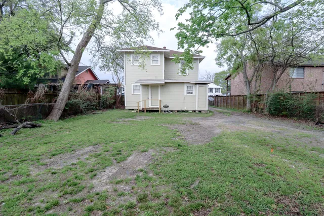 a view of a house with a yard and tree