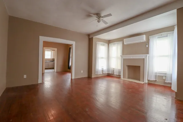 a view of a livingroom with wooden floor and a fireplace