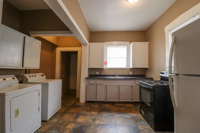 a kitchen with a stove top oven and cabinets