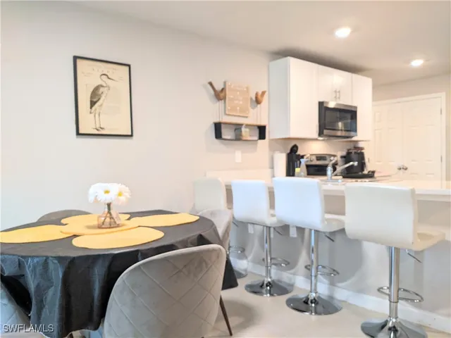 a dining room with table chairs and kitchen view