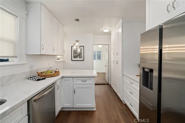 a kitchen with a refrigerator and white cabinets