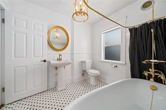 a bathroom with a sink a toilet and a mirror