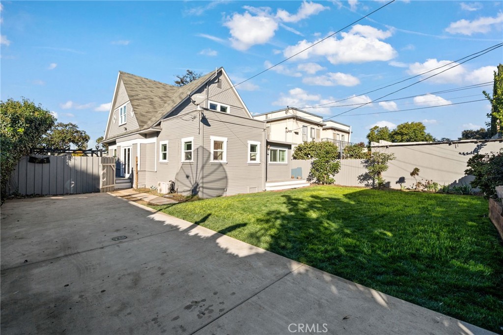 1148 Chestnut Avenue Long Beach, CA 90813 - Photo 31 of 32 a view of a white house next to a yard with big trees