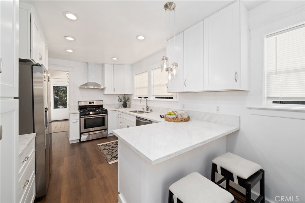 1148 Chestnut Avenue Long Beach, CA 90813 - Photo 10 of 32 a kitchen with a sink a stove a refrigerator and white cabinets