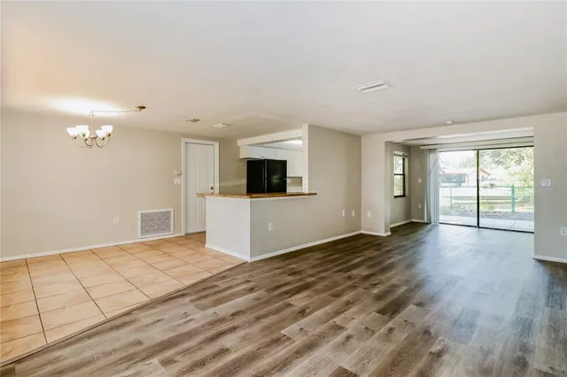 a view of a kitchen with wooden floor and a window