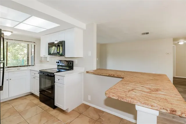 a kitchen with a stove window and cabinets