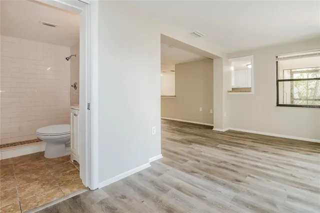 an empty room with wooden floor and a window
