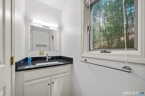 a bathroom with a granite countertop sink and a mirror