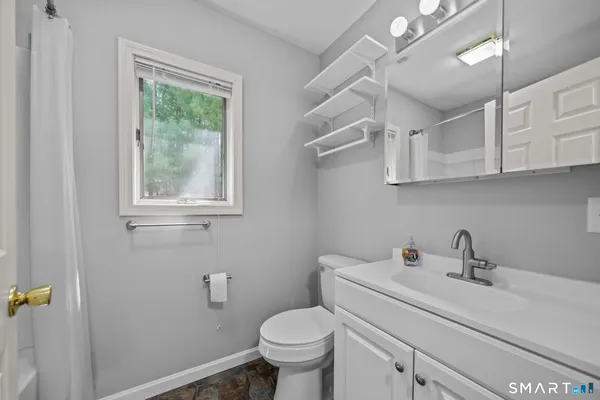 a bathroom with a sink a toilet and a window