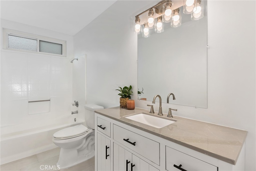 22246 Cardinal Street Grand Terrace, CA 92313 - Photo 15 of 28 a bathroom with a granite countertop sink a toilet and shower