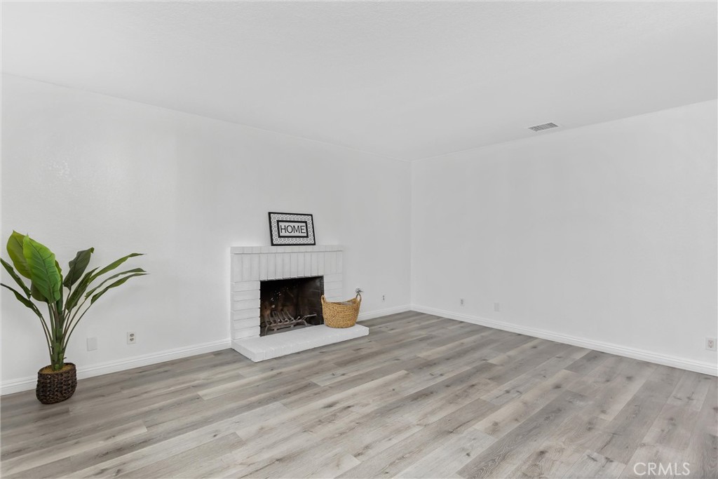 22246 Cardinal Street Grand Terrace, CA 92313 - Photo 6 of 28 a view of an empty room with wooden floor and a window