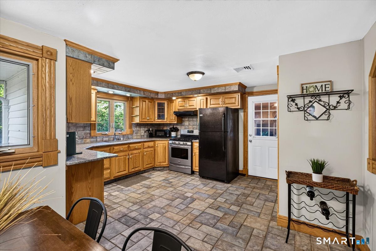 121 Hartford Road Simsbury, CT 06070 - Photo 7 of 31 Spacious eat-in kitchen featuring granite countertops, stainless steel appliances, a large pantry, and an open layout that flows seamlessly into the living room.
