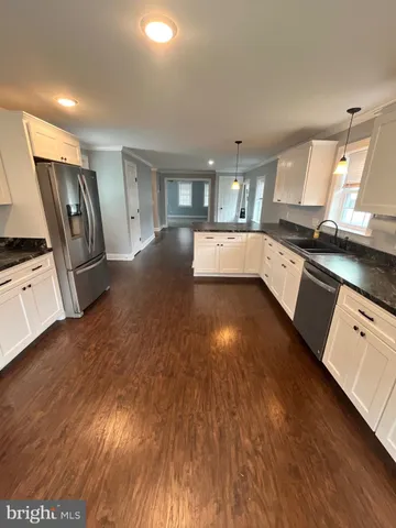 a large kitchen with stainless steel appliances granite countertop a stove a sink dishwasher and a oven with white cabinets