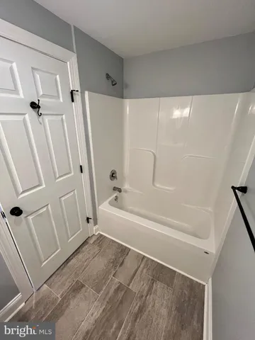 a bathroom with a tub a sink and a shower