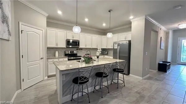 a living room with furniture a chandelier a large window and potted plants