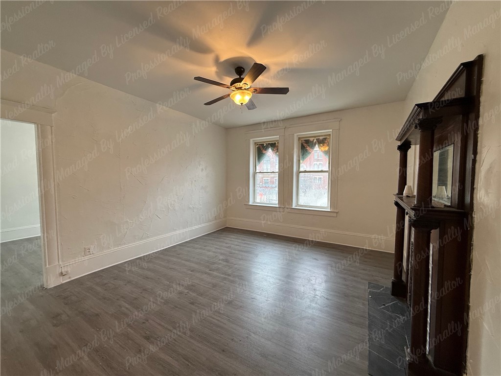 44 West High Street, Unit B Springfield, OH 45502 - Photo 6 of 31 This bright room features a classic fireplace and durable flooring, offering a comfortable living space.