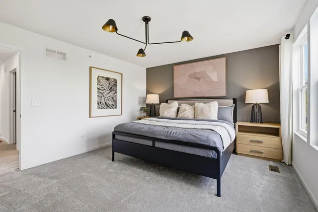 a bedroom with a bed and painting on the wall