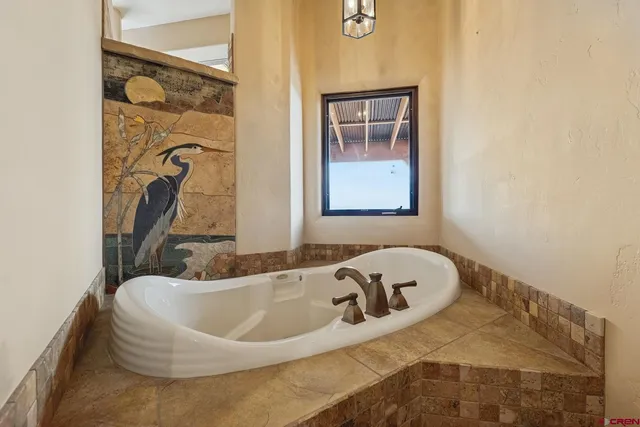 a bath tub sitting in a bathroom next to a window