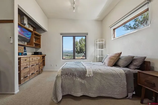 a spacious bedroom with a bed and wooden floor