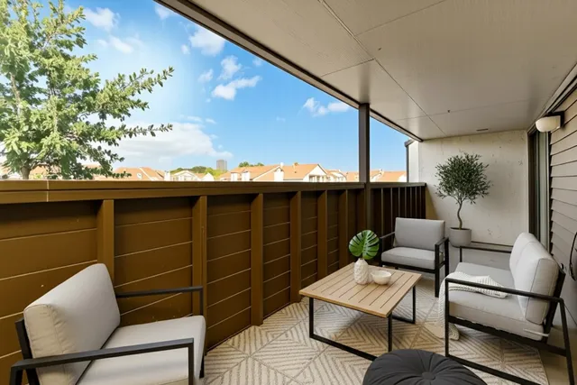 a balcony with furniture and a potted plant