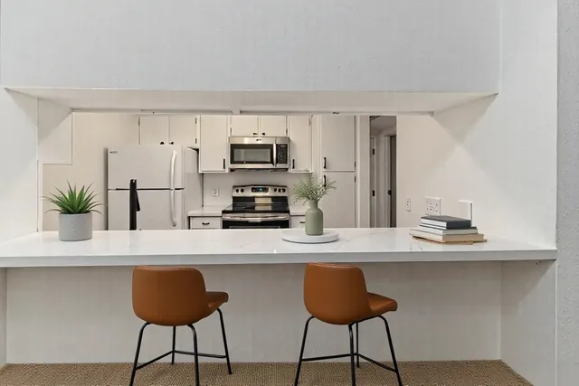 a kitchen with kitchen island granite countertop a counter space a sink and cabinets