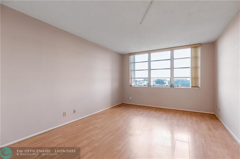 3520 Oaks Way, Unit 607 Pompano Beach, FL 33069 - Photo 15 of 31 an empty room with wooden floor and windows